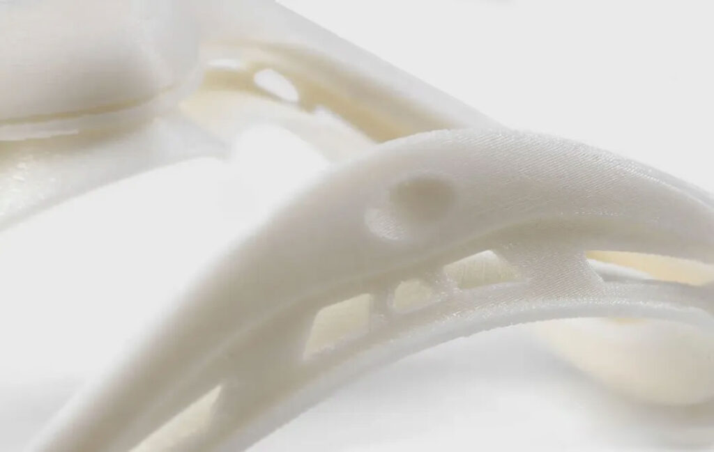 Figure: FDM part has visible layer lines and complex features are not printed clearly.